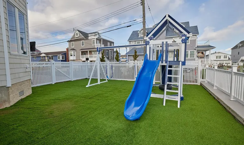 Fenced turf yard with a playset