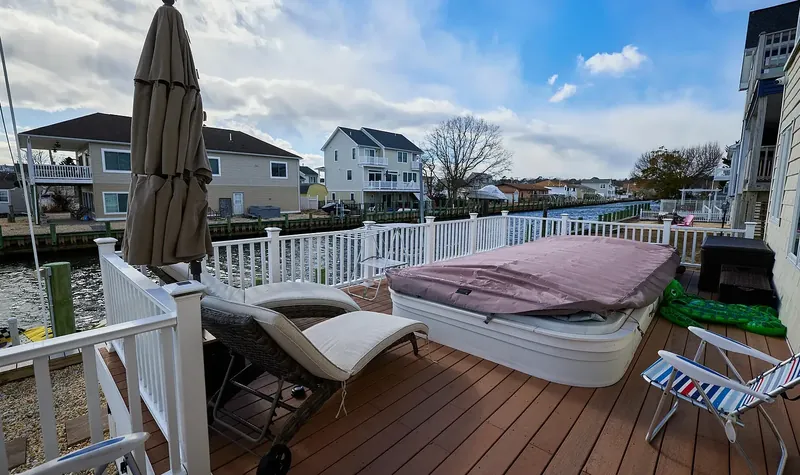 Hot tub and loungers on the waterside deck over the lagoon